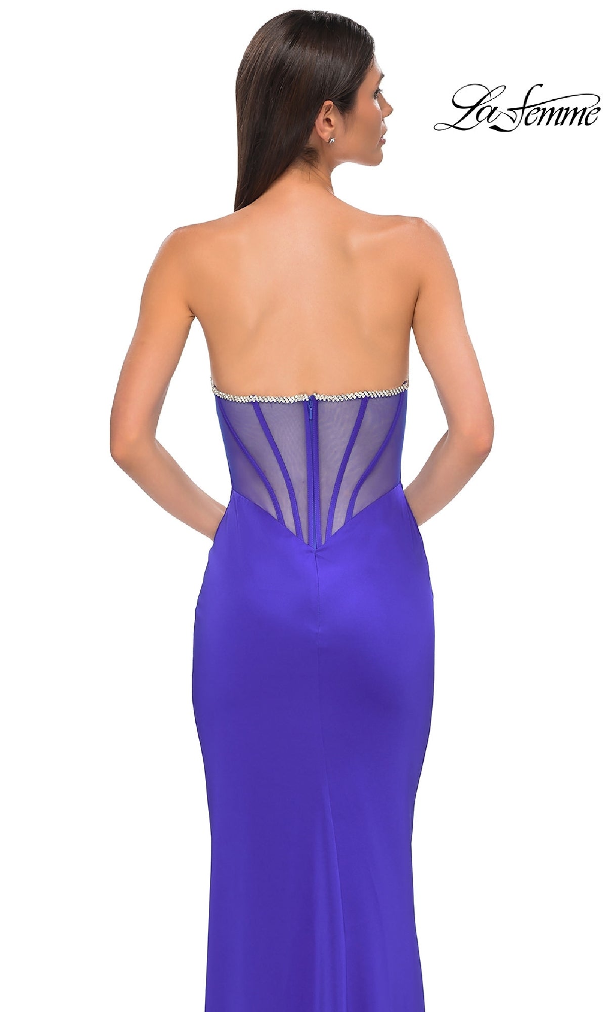Woman wearing the Bead-Trimmed Strapless Prom Dress: La Femme 32733—a fitted royal blue gown with a beaded sweetheart neckline and sheer back panel—standing against a white background.